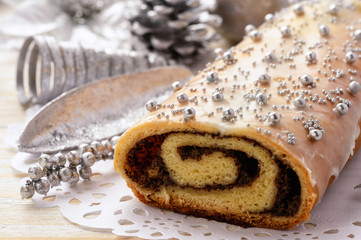 Christmas poppy seed roll on festive table.