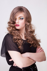 Fototapeta premium Glamour woman with crosed arms on gray background in studio phot