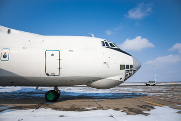 Close-up front view of widebody cargo airplane in a cold winter airport