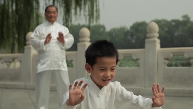 MS Young Boy And Mature Man Doing Tai Chi In A Park/ Beijing, China