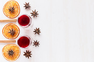 Christmas food - mulled wine background. Decorative frame of spice ingredients -  anise stars, cinnamon, dried oranges and wine on wood white surface. Top view.