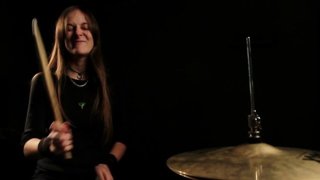 the drummer plays on Hihat in a dark room.