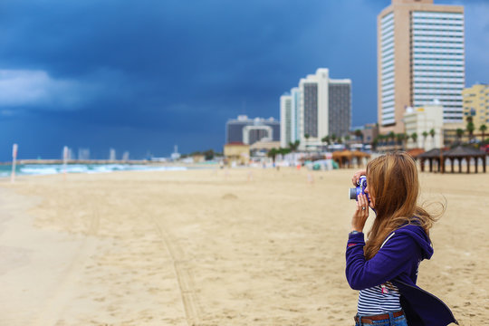 Girl photographer on the beach of the Mediterranean Sea in Israel
