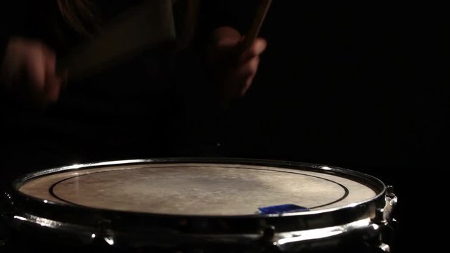 drummer playing in a dark room . Close-up