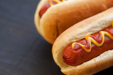 Barbecue Grilled Hot Dog with Yellow Mustard and ketchup on wooden table