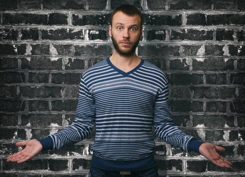 portrait young man shrugging shoulders