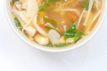 Hot and Spicy Soup with mushroom, mix vegetable and Thai herbs in white bowl on white background ,Vegetarian Food, Healthy food