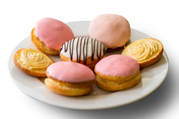 Colorful biscuits on a plate. Cookies with icing. Bush cakes with custard filling. Traditional sweets from crispy dough.