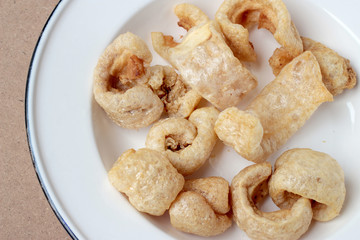 Streaky pork with crispy crackling in white dish on wooden background
