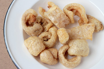 Streaky pork with crispy crackling in white dish on wooden background