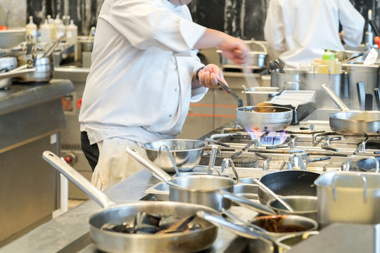 male cooks preparing meals in restaurant kitchen

