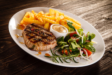 Grilled steak, French fries and vegetables