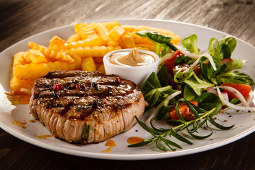 Grilled steak, French fries and vegetables