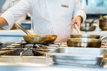 male cooks preparing meals in restaurant kitchen

