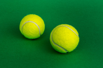 two tennis balls on a green background