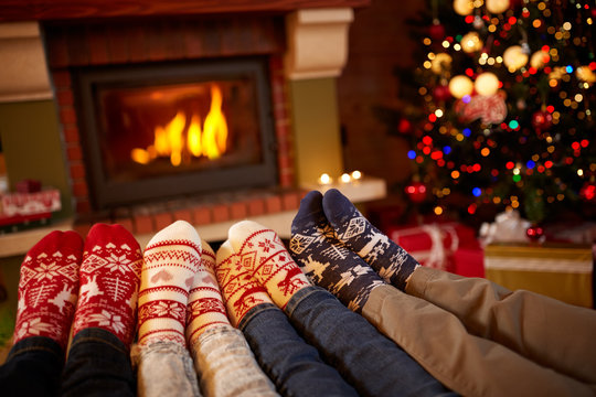 Feet in wool socks near fireplace in winter.