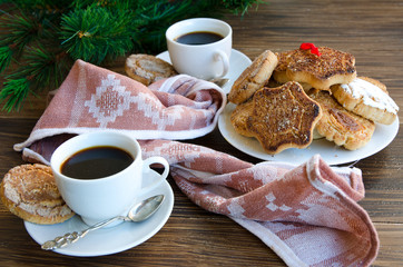 Mantecados, typical sweets consumed in Spain at Christmas. Spanish shortbread served with black coffee on wooden background with fir tree.