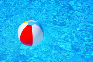 Colorful inflatable ball floating in swimming pool