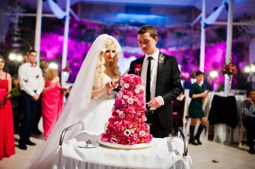 Wedding couple with sweet wedding cake with pink roses