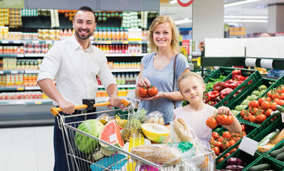 Parents with daughter choosing veggies