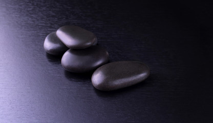 black stones for Thai spa on black wooden background