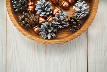 Christmas composition.White cones and golden acorns.Wooden white table.Top view
