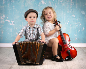 zwei kleine Kinder musizieren mit Instrumenten