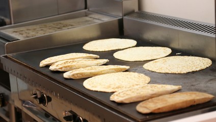 many piadina on hot griddle of a restaurant in Italy