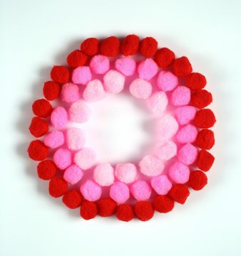 circle of red, pink little pompons on a white background 1