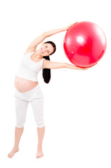 Portrait of a beautiful young pregnant woman executing exercises with fitball
