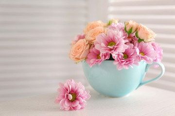 Bouquet of beautiful flowers in a cup on a  table
