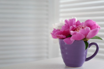 Bouquet of beautiful flowers in a cup on a  table