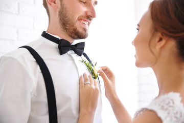 Groom and bride on white brick wall background