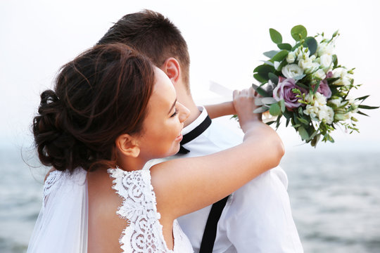 Groom and bride on river bank at romantic moment