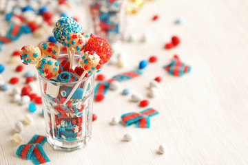Glass with colorful small candies on table