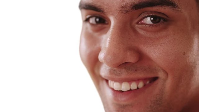 Close up of smiling millennial Hispanic man on white background with copy space. Happy Mexican guy looking at camera with copyspace