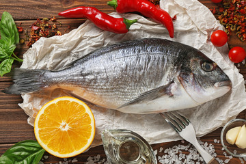 Raw fish with spices on wooden table