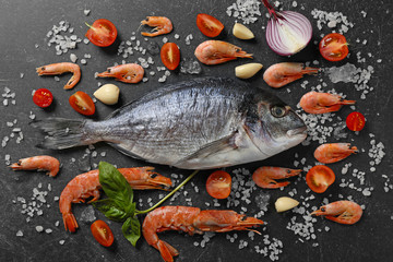 Raw fish with spices and shrimps on table