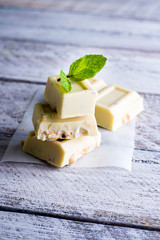 White chocolate with nut on a white wood background. Copy space