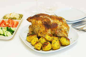 Roasted chicken and potatoes on white plate