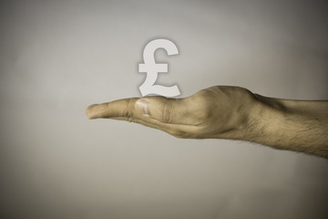 Human hand on vintage background keeping Pound symbol