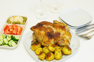 Roasted chicken and potatoes on white plate