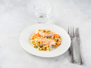 Steamed salmon with vegetables on white plate