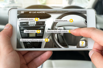 Augmented reality marketing , customer relationship concept. Hand holding smart phone use AR application to check manual of inside car for customer. Flare light.