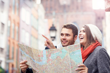 Pretty couple sightseeing with map
