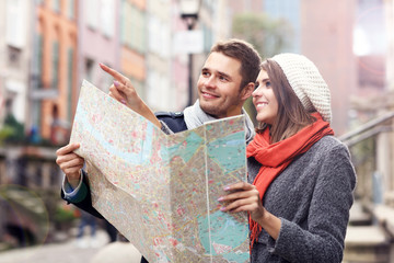 Pretty couple sightseeing with map