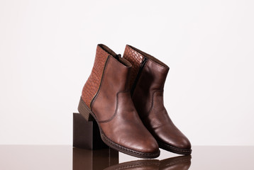 Brown leather booties on a little black box