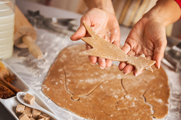 Closeup on young housewife showing carved from dough christmas c
