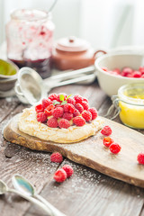 Raspberry Dessert with Lemon Curd and Icing Sugar on Dark Wooden Background