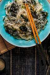 Funchoza salad with wakame on dark background. © tbralnina